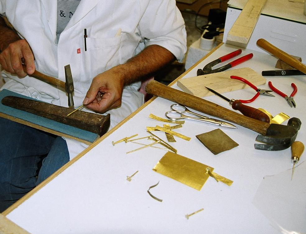 confection des pièces métalliques et des clous (en laiton martelé et vieilli) à l ́identique des pièces d ́origine